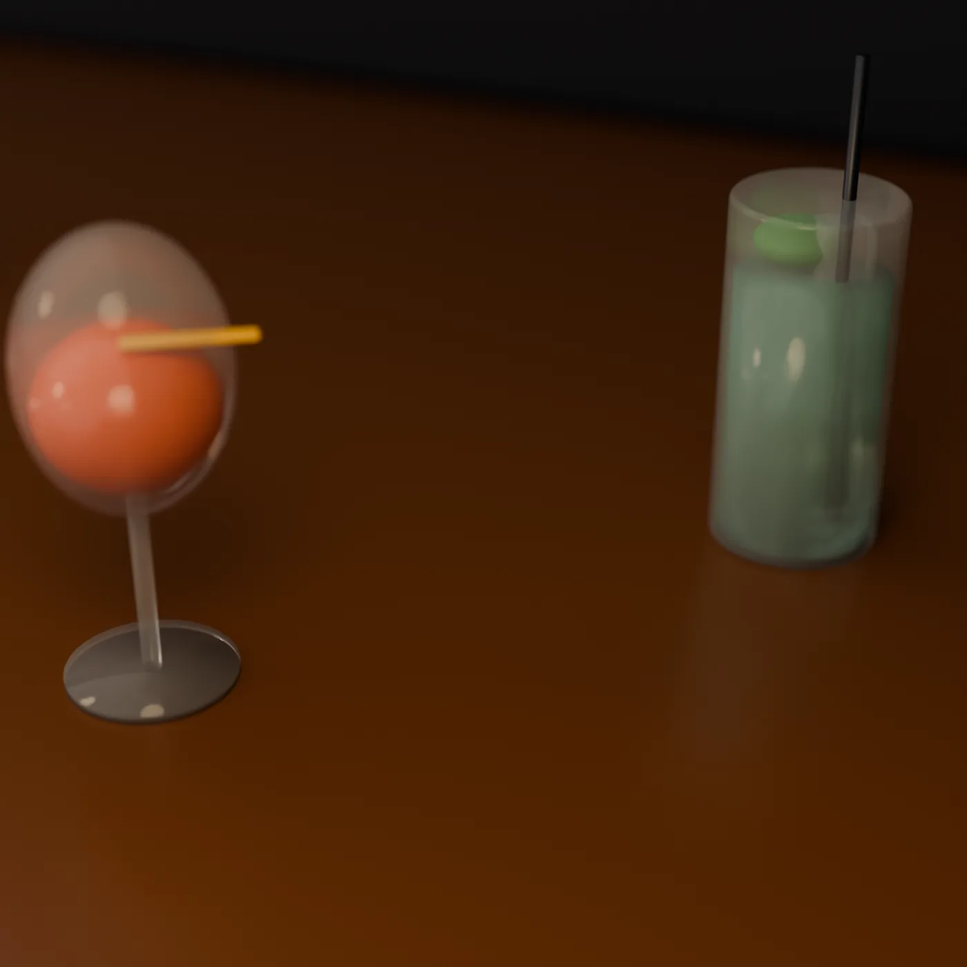 An orange cocktail in a coupe and a green highball with ice